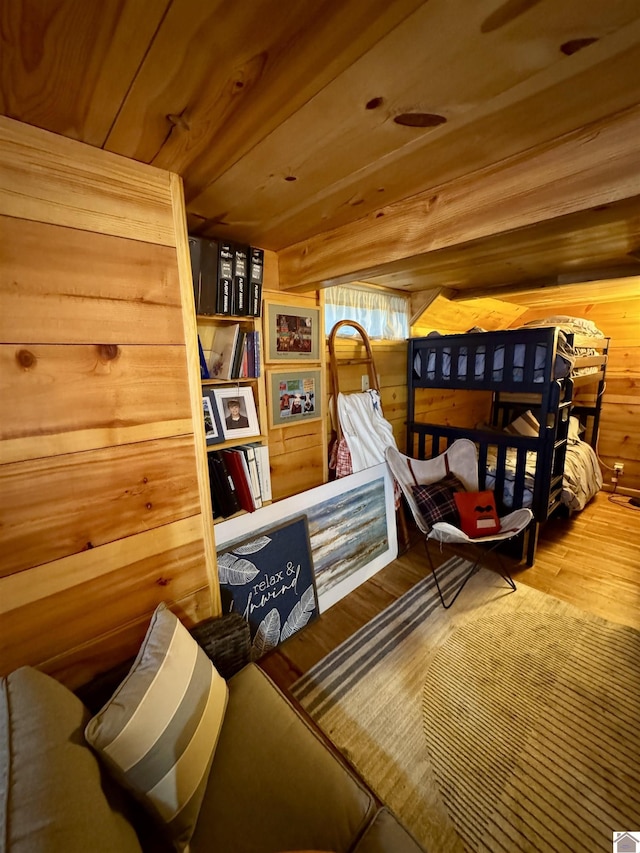 sitting room with wood finished floors, wood ceiling, and wooden walls