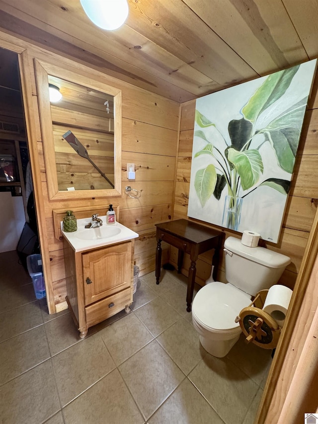 half bath with tile patterned flooring, toilet, wood walls, vanity, and wood ceiling