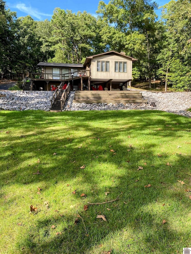 view of front facade with a deck, a front yard, and stairway