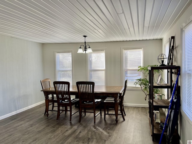 dining room with a chandelier, dark wood-style flooring, and baseboards