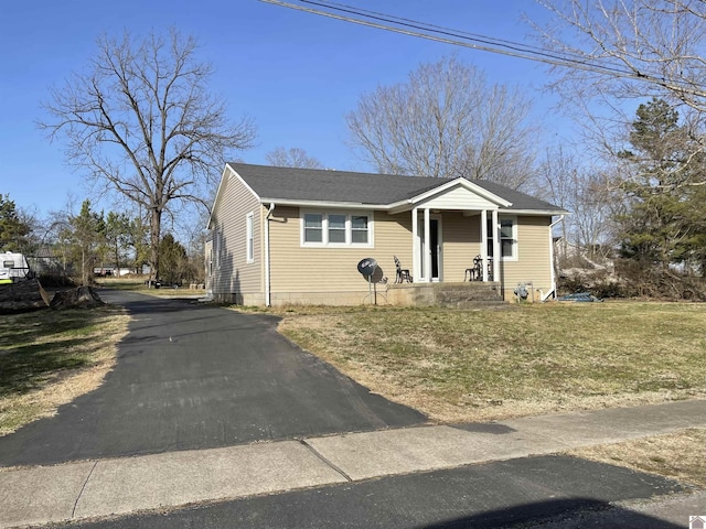 bungalow-style house featuring roof with shingles and a front yard