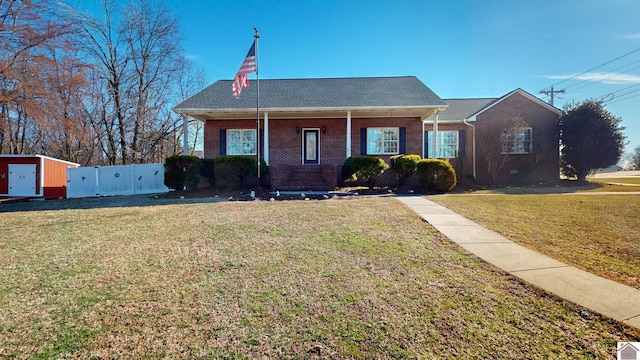 view of front of house featuring brick siding, a front lawn, and fence