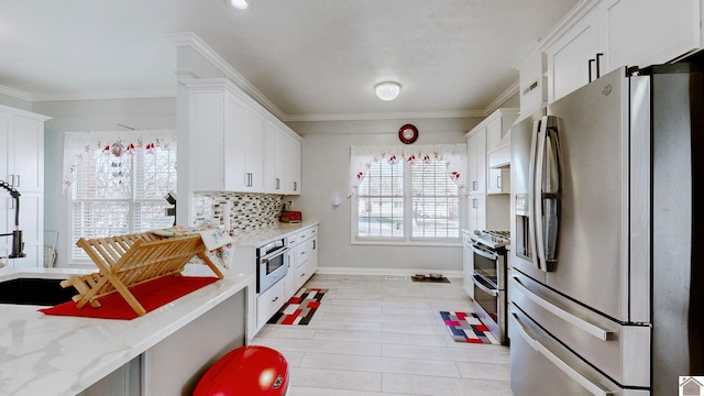 kitchen featuring baseboards, white cabinets, appliances with stainless steel finishes, crown molding, and backsplash