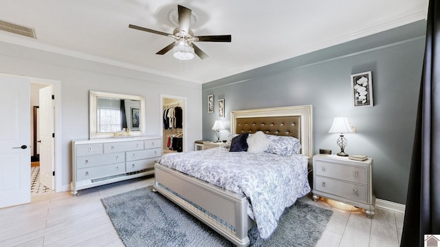 bedroom featuring baseboards, visible vents, a spacious closet, a closet, and crown molding