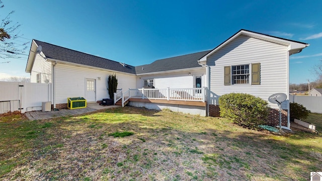 back of house featuring a gate, fence, a lawn, and a wooden deck