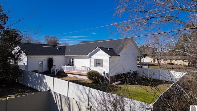 view of side of property with a deck and a fenced backyard