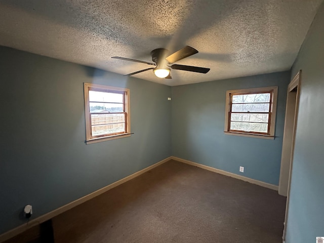 unfurnished room featuring ceiling fan, a textured ceiling, baseboards, and dark colored carpet