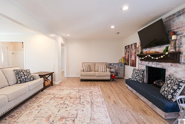 living area with a brick fireplace, recessed lighting, wood finished floors, and ornamental molding