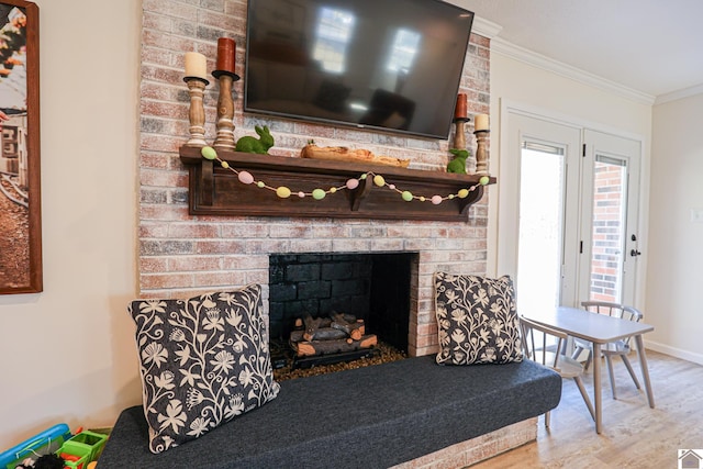 living room featuring a fireplace, wood finished floors, baseboards, and ornamental molding