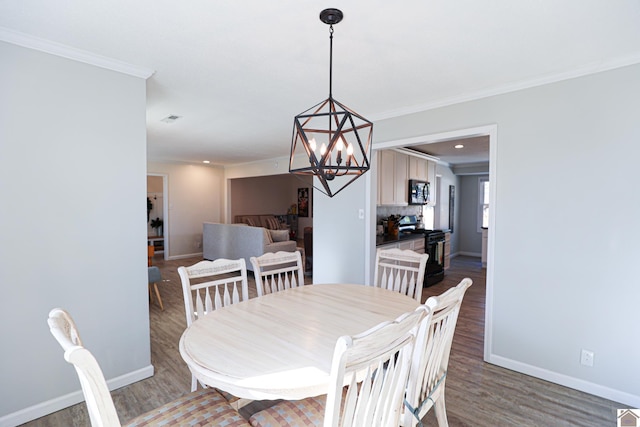 dining room featuring baseboards, a notable chandelier, wood finished floors, and ornamental molding