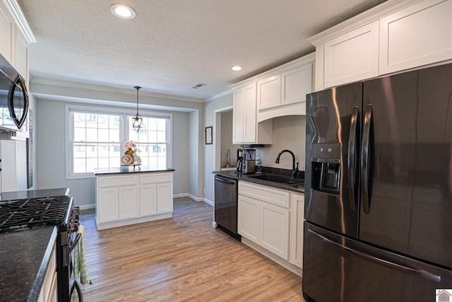 kitchen with a sink, black appliances, white cabinets, crown molding, and light wood-type flooring