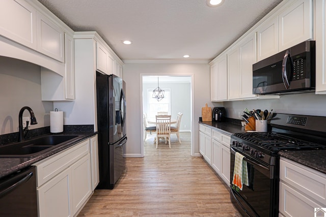 kitchen featuring white cabinets, black appliances, and a sink