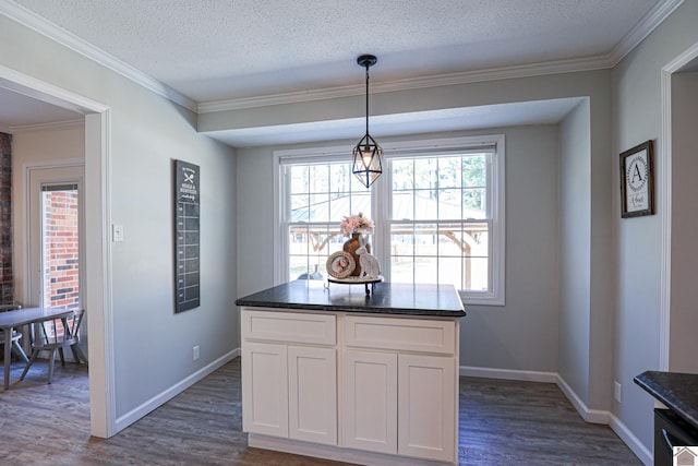 kitchen with white cabinetry, crown molding, dark wood finished floors, and a textured ceiling