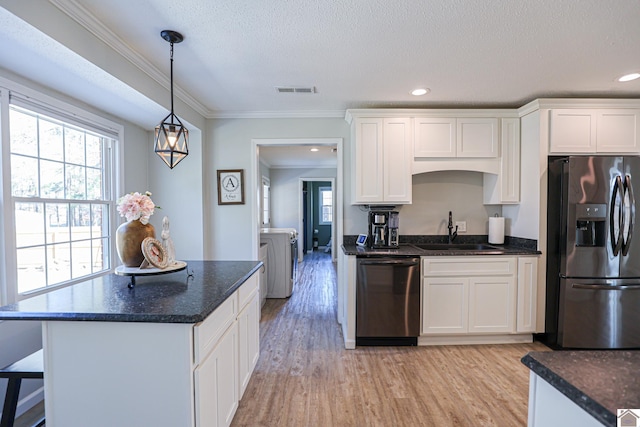 kitchen with light wood-type flooring, independent washer and dryer, a sink, stainless steel appliances, and white cabinets