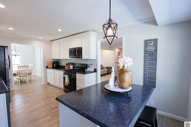 kitchen featuring black appliances, white cabinets, light wood-style flooring, and dark countertops