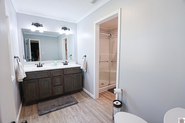 bathroom featuring a sink, wood finished floors, toilet, and a stall shower