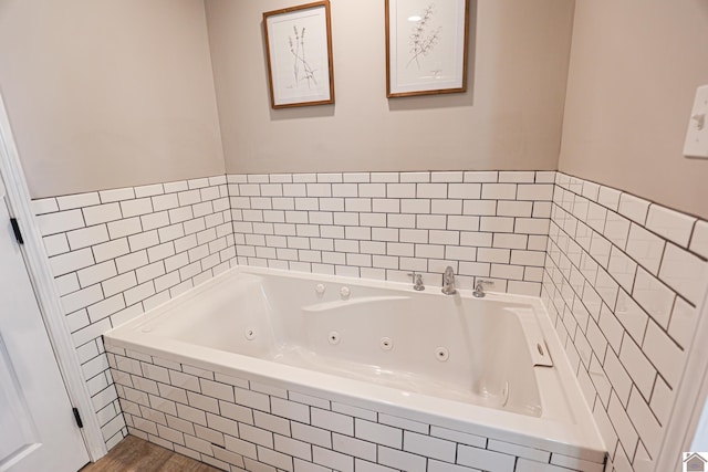 full bath featuring wood finished floors and a whirlpool tub