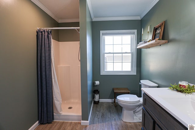 bathroom with a stall shower, crown molding, baseboards, and wood finished floors