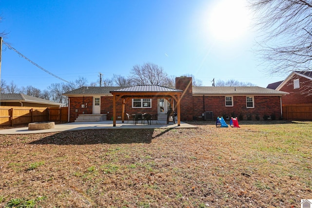 back of house featuring a patio, brick siding, and an outdoor fire pit