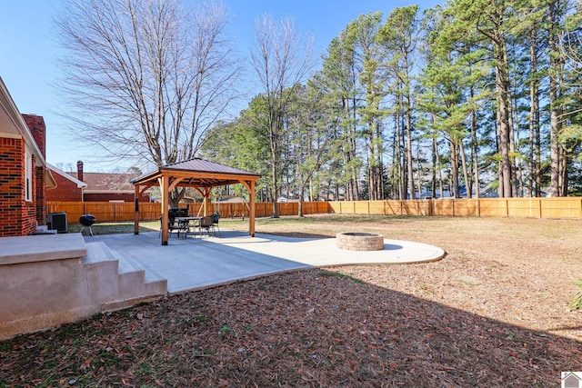 view of yard with an outdoor fire pit, a gazebo, central AC unit, a fenced backyard, and a patio area