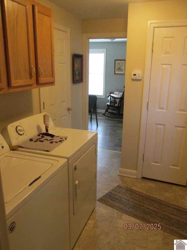 washroom featuring baseboards, cabinet space, and washing machine and clothes dryer