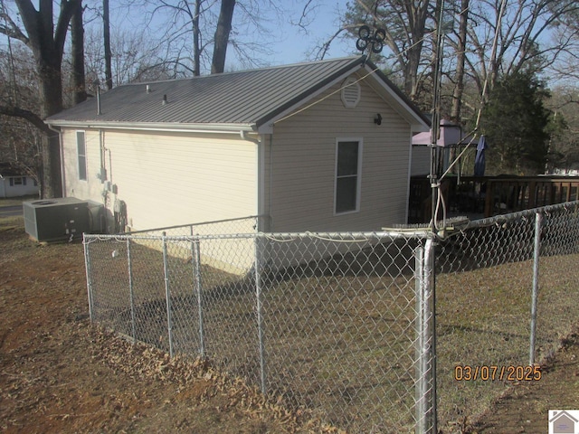 view of home's exterior with metal roof and fence