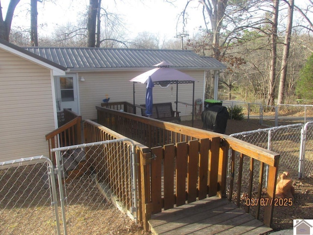 wooden deck with grilling area, fence private yard, and a gate