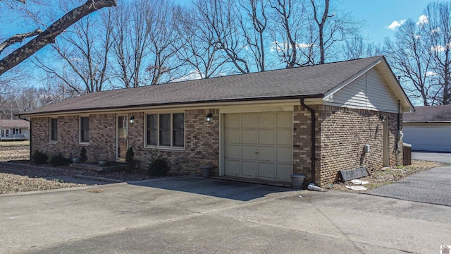 single story home featuring brick siding, an attached garage, and concrete driveway