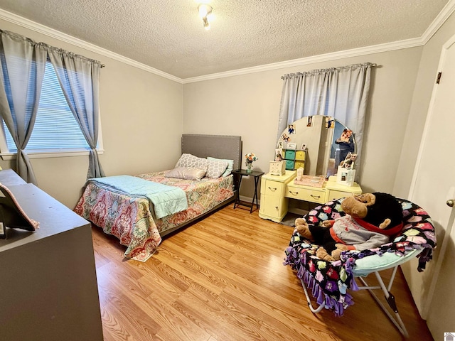 bedroom featuring ornamental molding, a textured ceiling, and wood finished floors