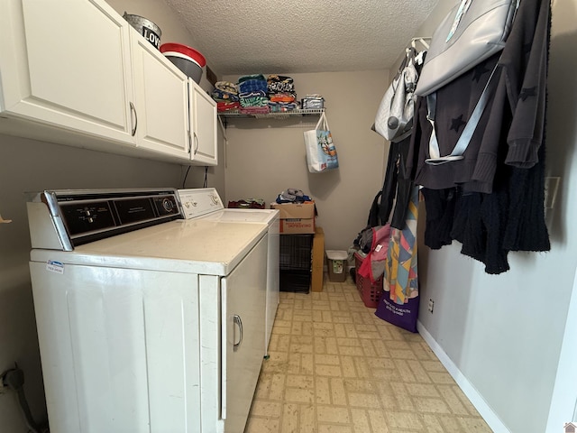 washroom featuring a textured ceiling, cabinet space, baseboards, light floors, and washing machine and clothes dryer