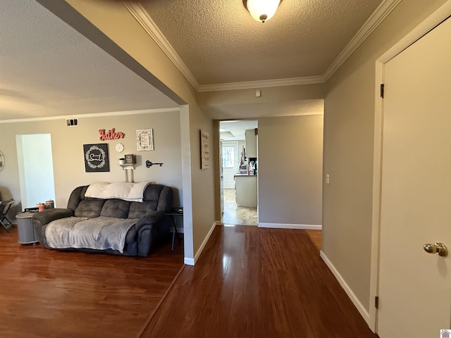 hallway featuring crown molding, wood finished floors, baseboards, and a textured ceiling