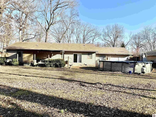 back of house with a covered pool