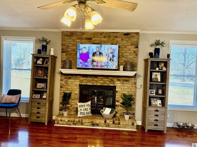 living area with crown molding, a brick fireplace, and a wealth of natural light