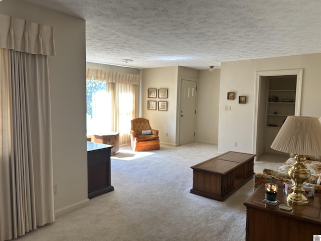 living room with carpet flooring, a textured ceiling, and baseboards