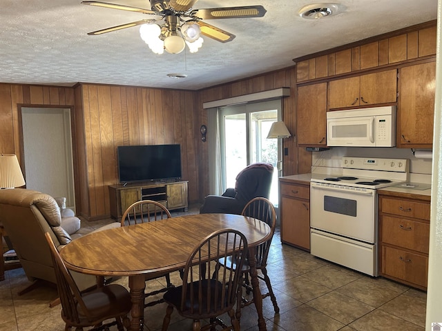 kitchen with white appliances, visible vents, light countertops, a textured ceiling, and brown cabinets