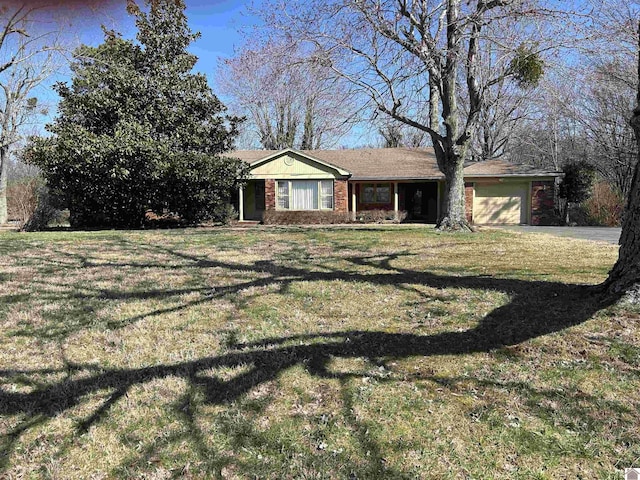 view of front of property with a garage, driveway, brick siding, and a front yard