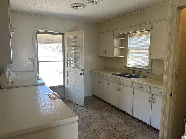 kitchen with visible vents, washing machine and clothes dryer, a sink, light countertops, and white cabinets