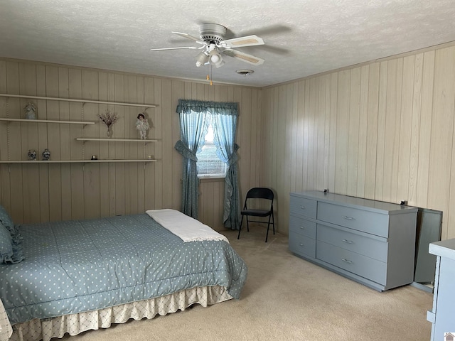 bedroom with a ceiling fan, light colored carpet, and a textured ceiling