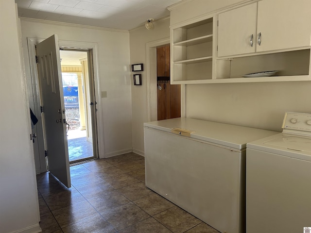 clothes washing area featuring washer / dryer, cabinet space, baseboards, and ornamental molding