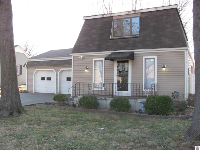 colonial inspired home with mansard roof, covered porch, concrete driveway, an attached garage, and a shingled roof