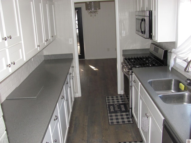 kitchen featuring a sink, dark wood-style floors, white cabinetry, and stainless steel appliances