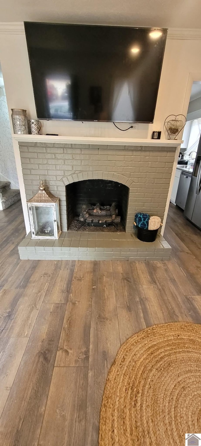 interior details with a fireplace, wood finished floors, and ornamental molding