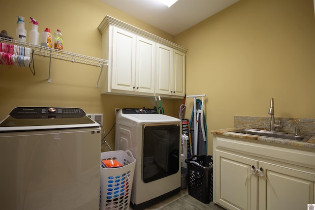 laundry area with washer and clothes dryer, cabinet space, and a sink