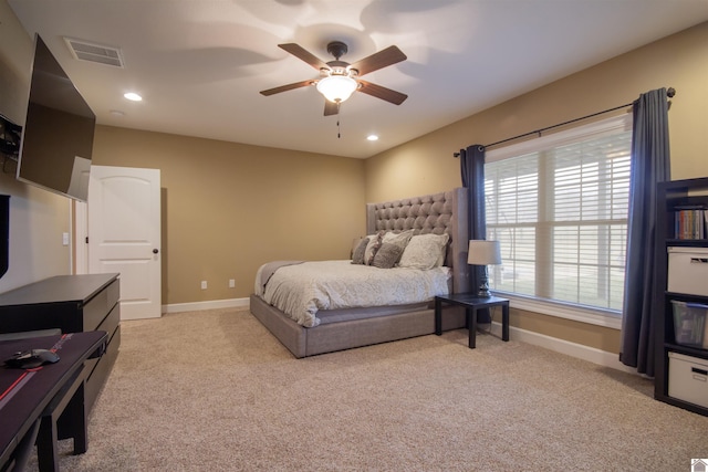 bedroom featuring visible vents, light colored carpet, and baseboards