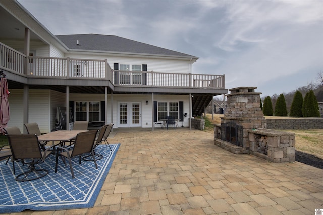 view of patio featuring a deck, outdoor dining area, and an outdoor stone fireplace