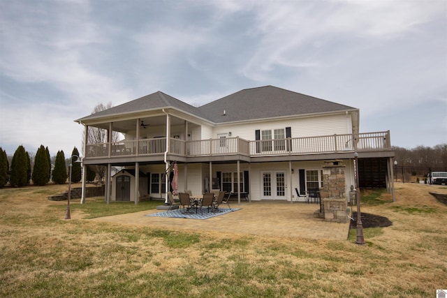 rear view of property with a patio, a ceiling fan, an outdoor structure, a storage unit, and a deck