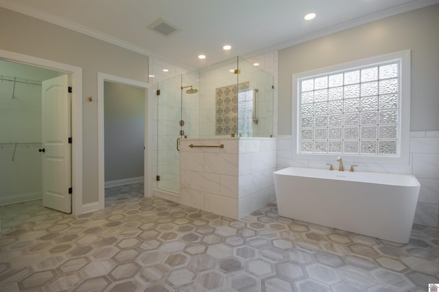 165 Valor Ct, Paducah, KY 42003 - bathroom with a shower stall, a freestanding tub, crown molding, a walk in closet, and tile walls
