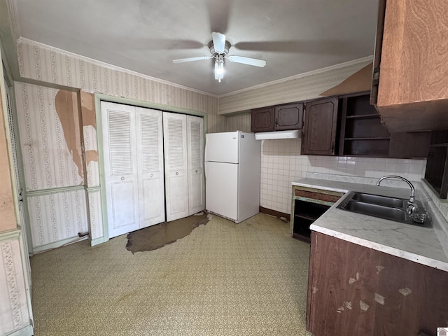 kitchen featuring wallpapered walls, open shelves, freestanding refrigerator, a sink, and dark brown cabinets