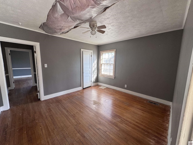 unfurnished bedroom featuring visible vents, baseboards, a textured ceiling, and hardwood / wood-style flooring