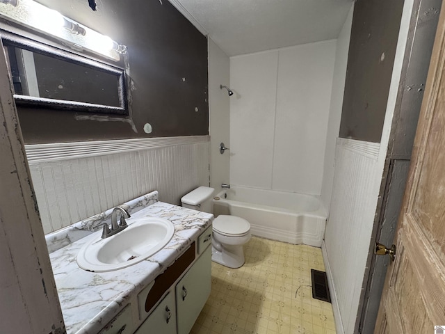 full bath featuring tile patterned floors, visible vents, toilet, and a wainscoted wall